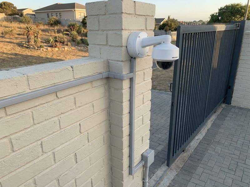 CCTV technician installing security cameras at a residential villa gate